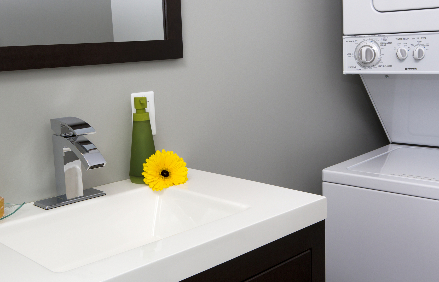 A suite bathroom vanity beside an in-suite laundry machine.